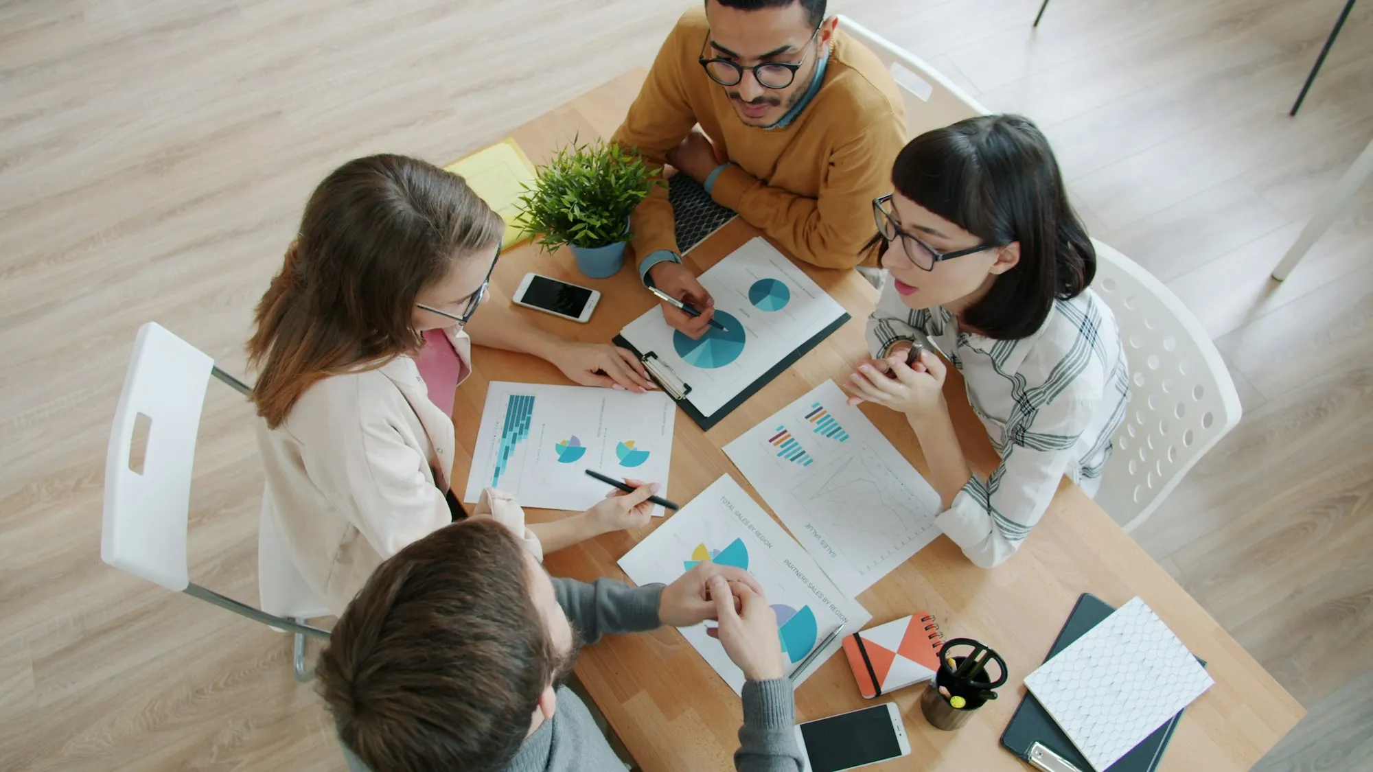 Equipe analisando relatórios e gráficos de desempenho sobre uma mesa